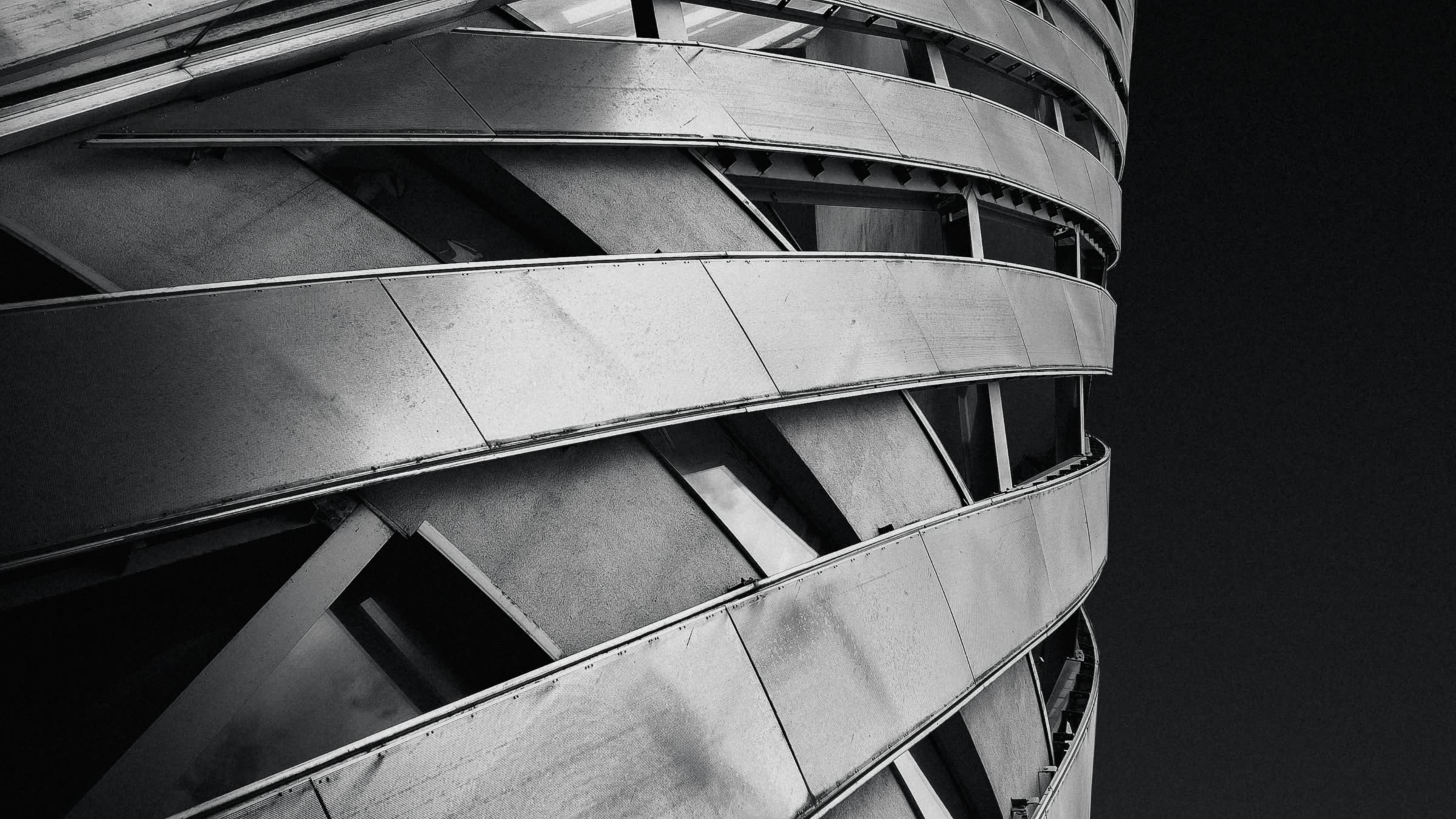 Curved steel bands wrapping a building, against a dark sky